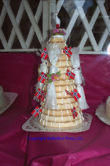 Kransekake or Crown Cake, is Norway's most famous cake. It consists of concentric rings of almond paste dough decorated with Norwegian flags and drizzled with vanilla cream icing.